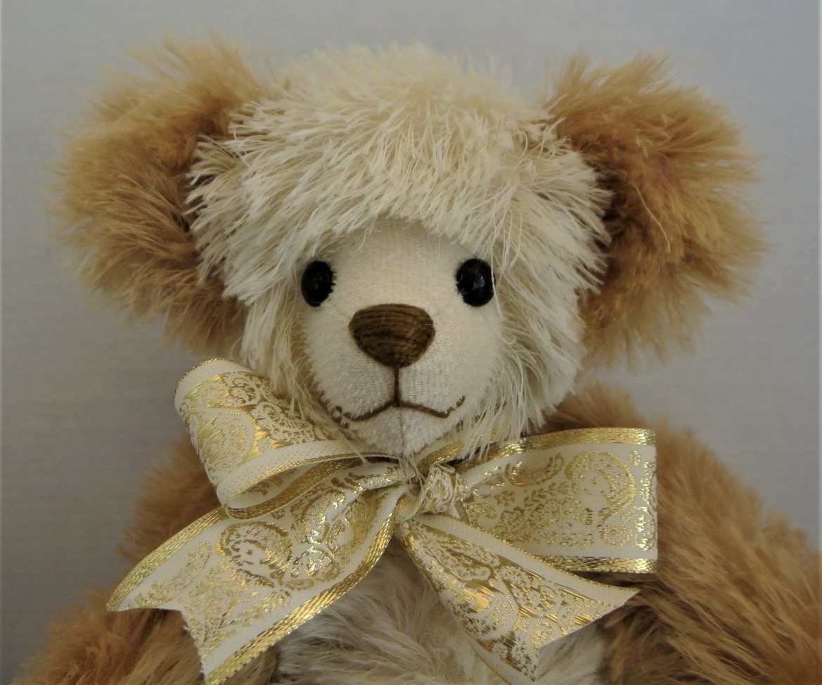Handmade golden bear wearing an ornate bow