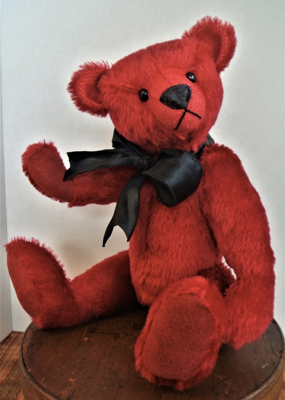 Handmade red bear wearing a black bow
